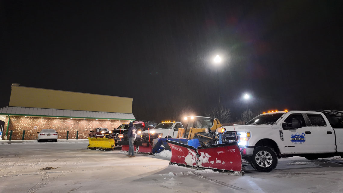 JRW Services plow fleet working a commercial lot in the middle of a night snowstorm