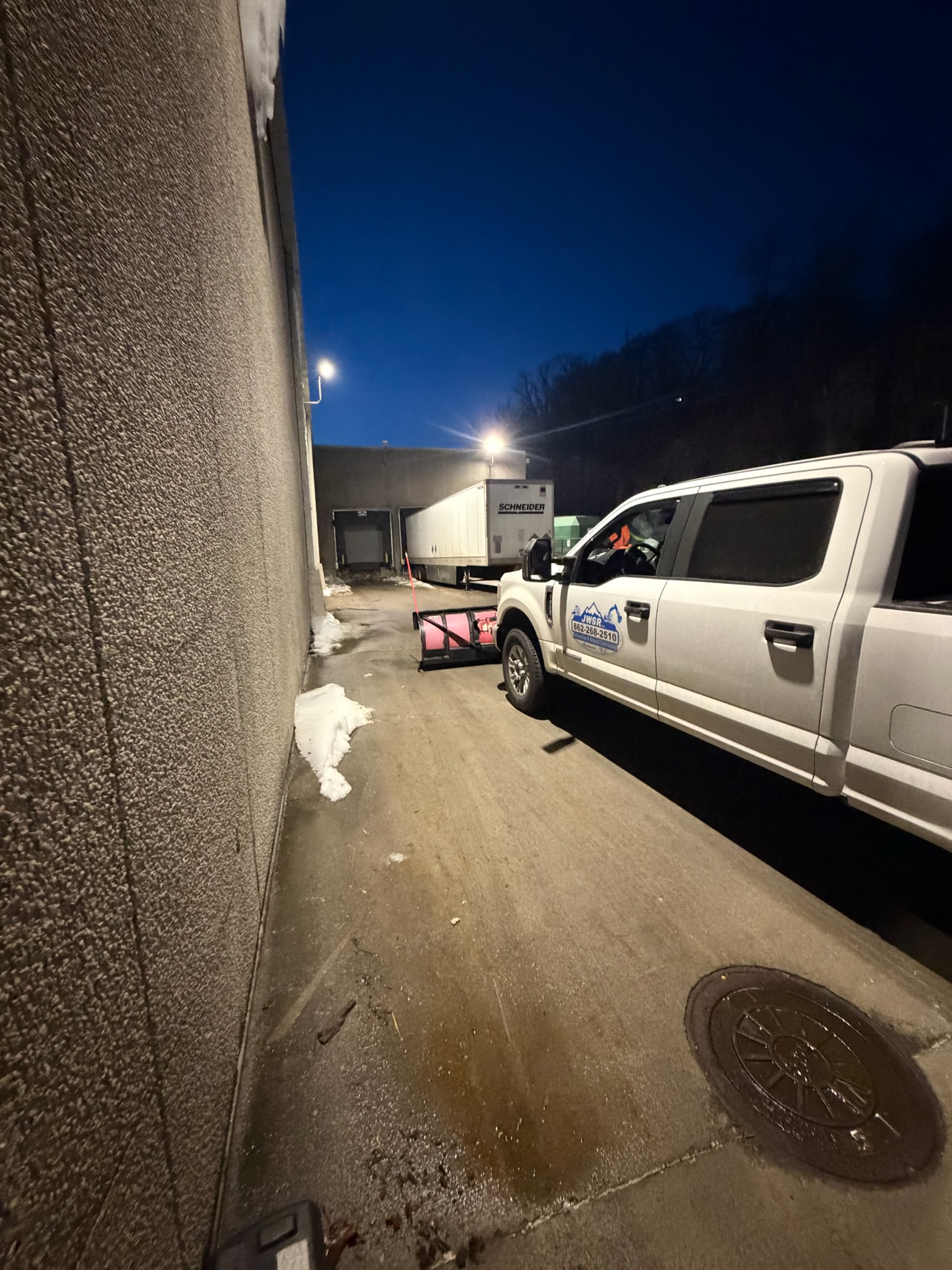 JRW Services truck staged at an industrial loading dock at night
